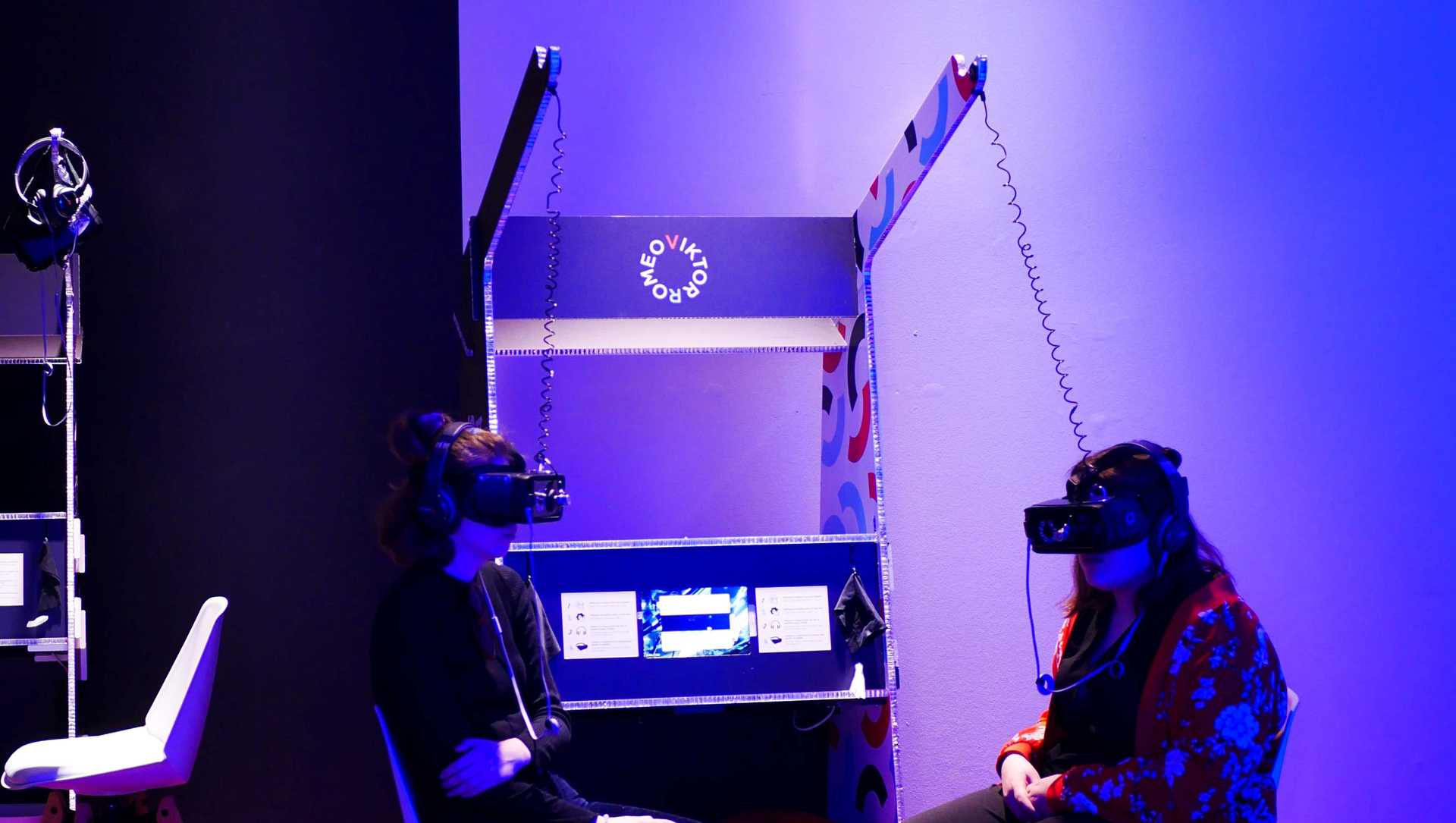 Two people sitting in a room with VR-headsets