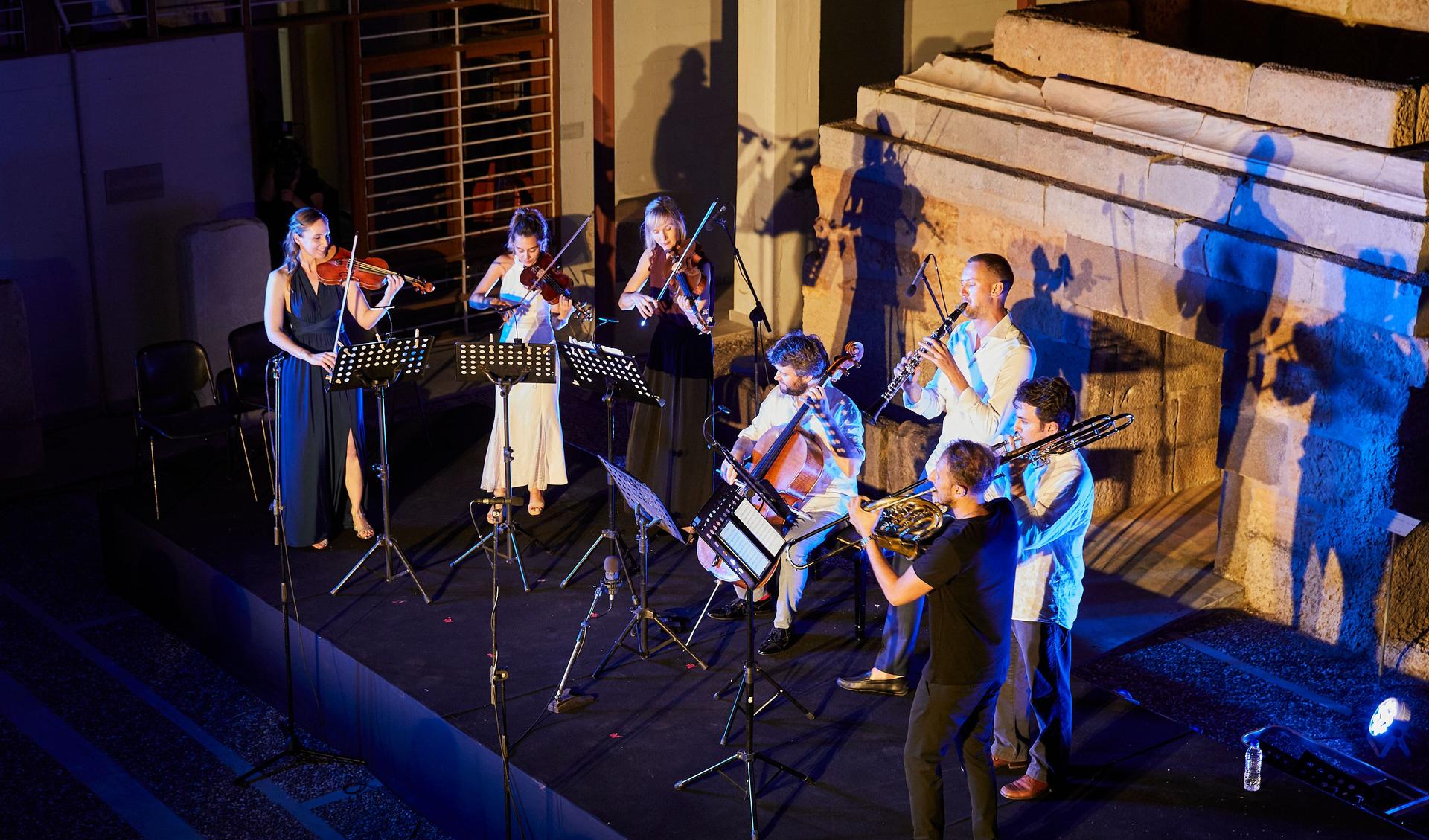 A orchester is standing on a stage and plays music