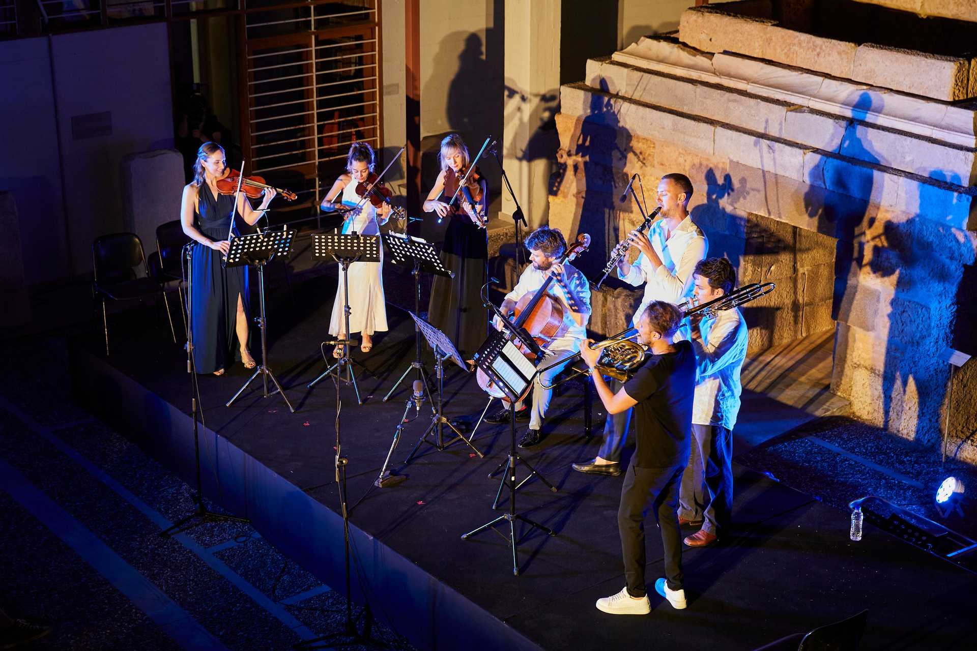 A orchester is standing on a stage and plays music