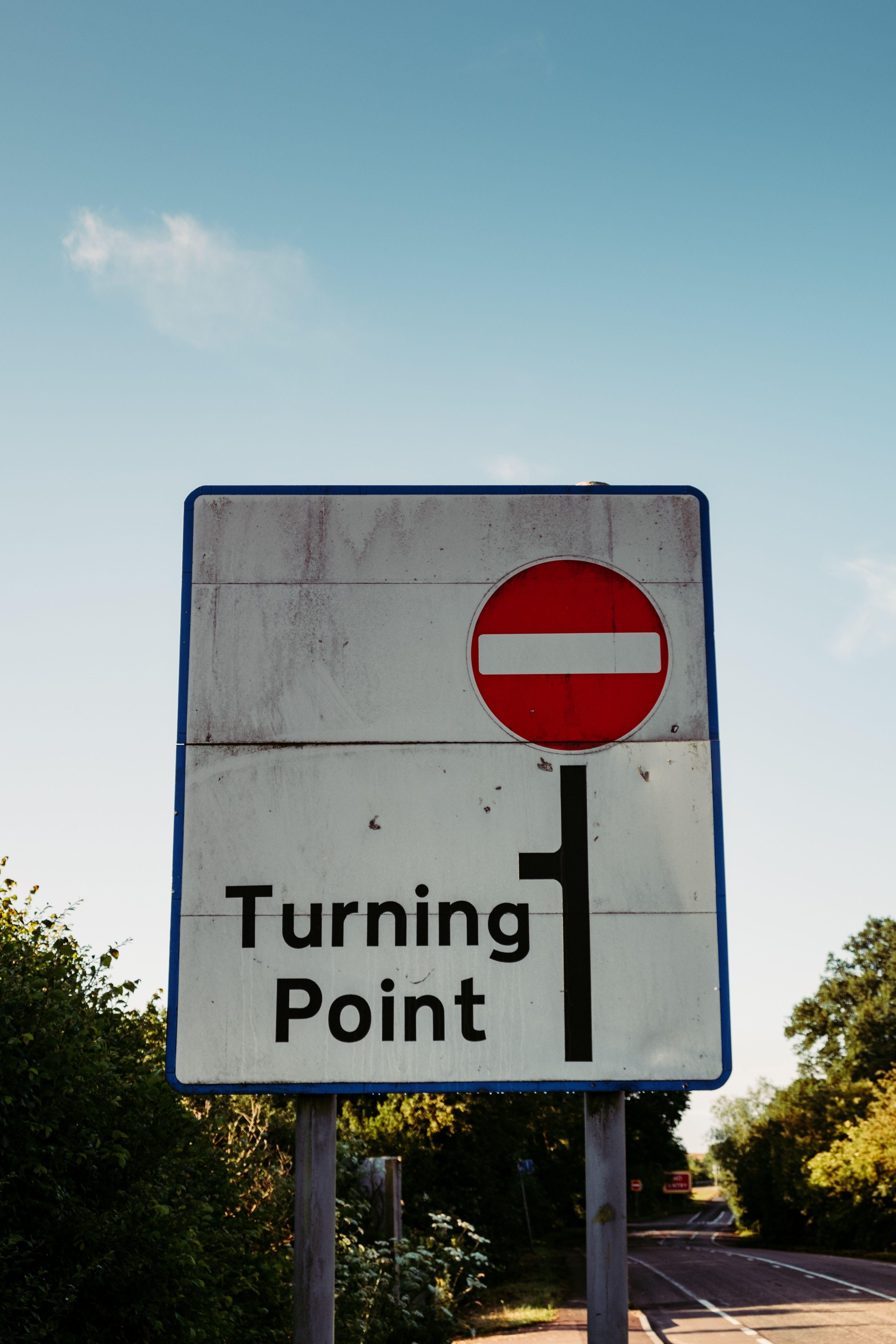 A traffic sign says Turning point and marks the end of the road