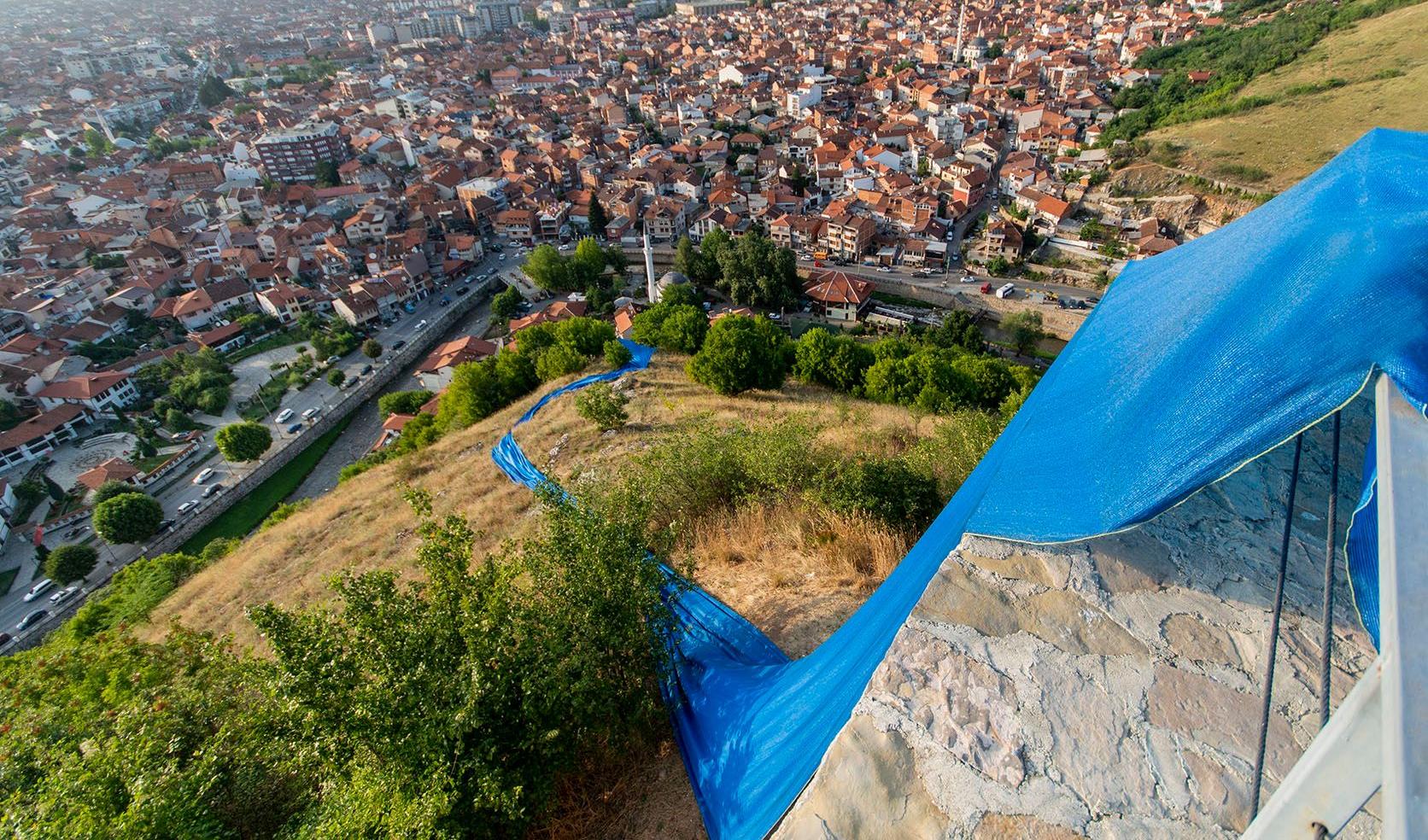 Streams of blue fabric by Hera Büyüktaşciya runs down a hill near Prizren