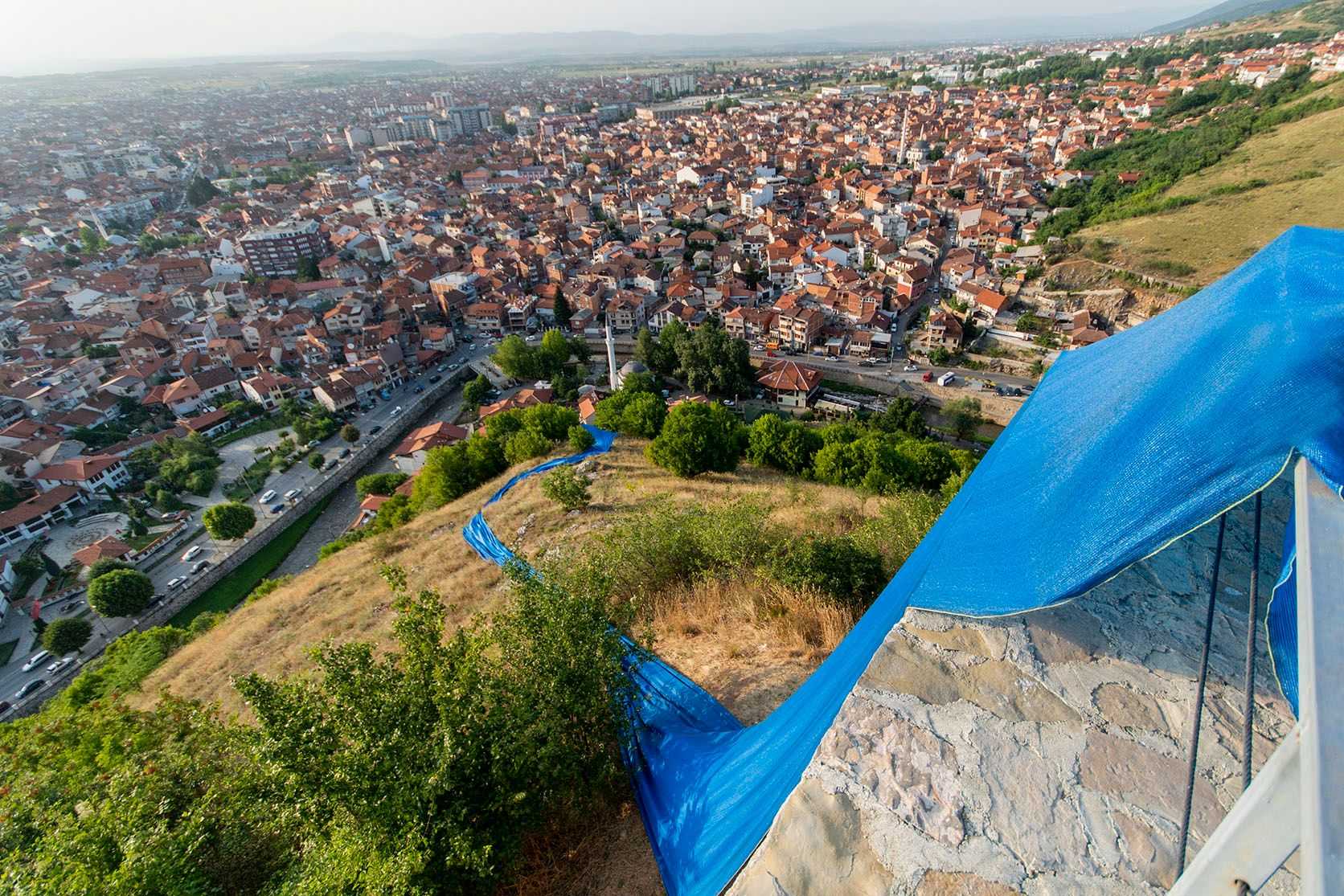 Streams of blue fabric by Hera Büyüktaşciya runs down a hill near Prizren