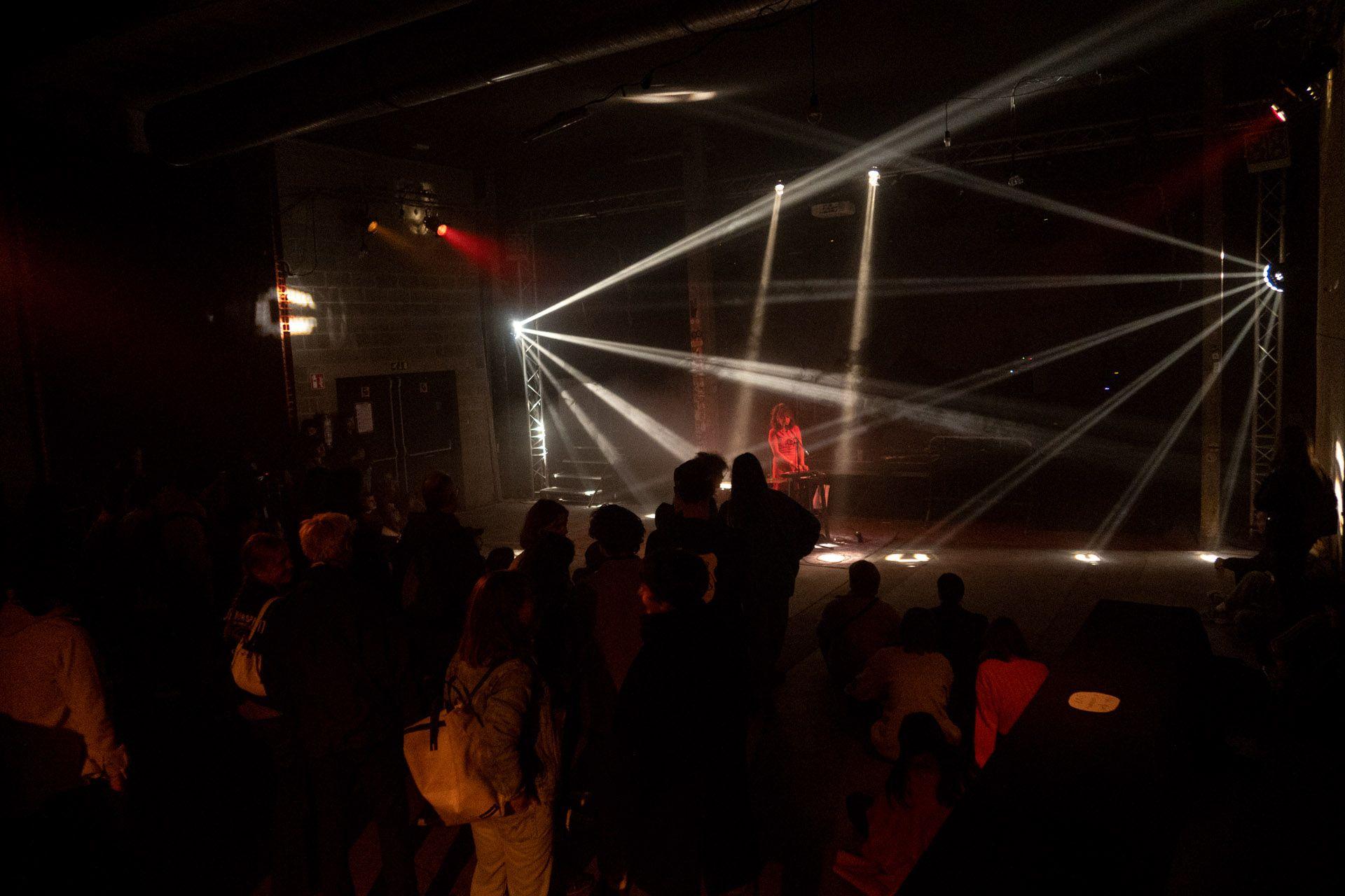 People are listening to a concert in a small hall.