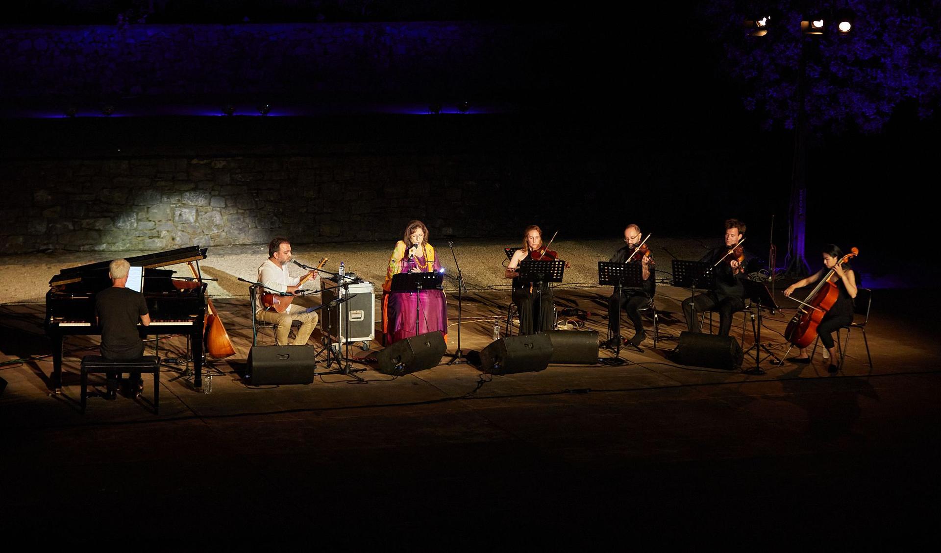 An orchester plays in the night on a rocky landscape