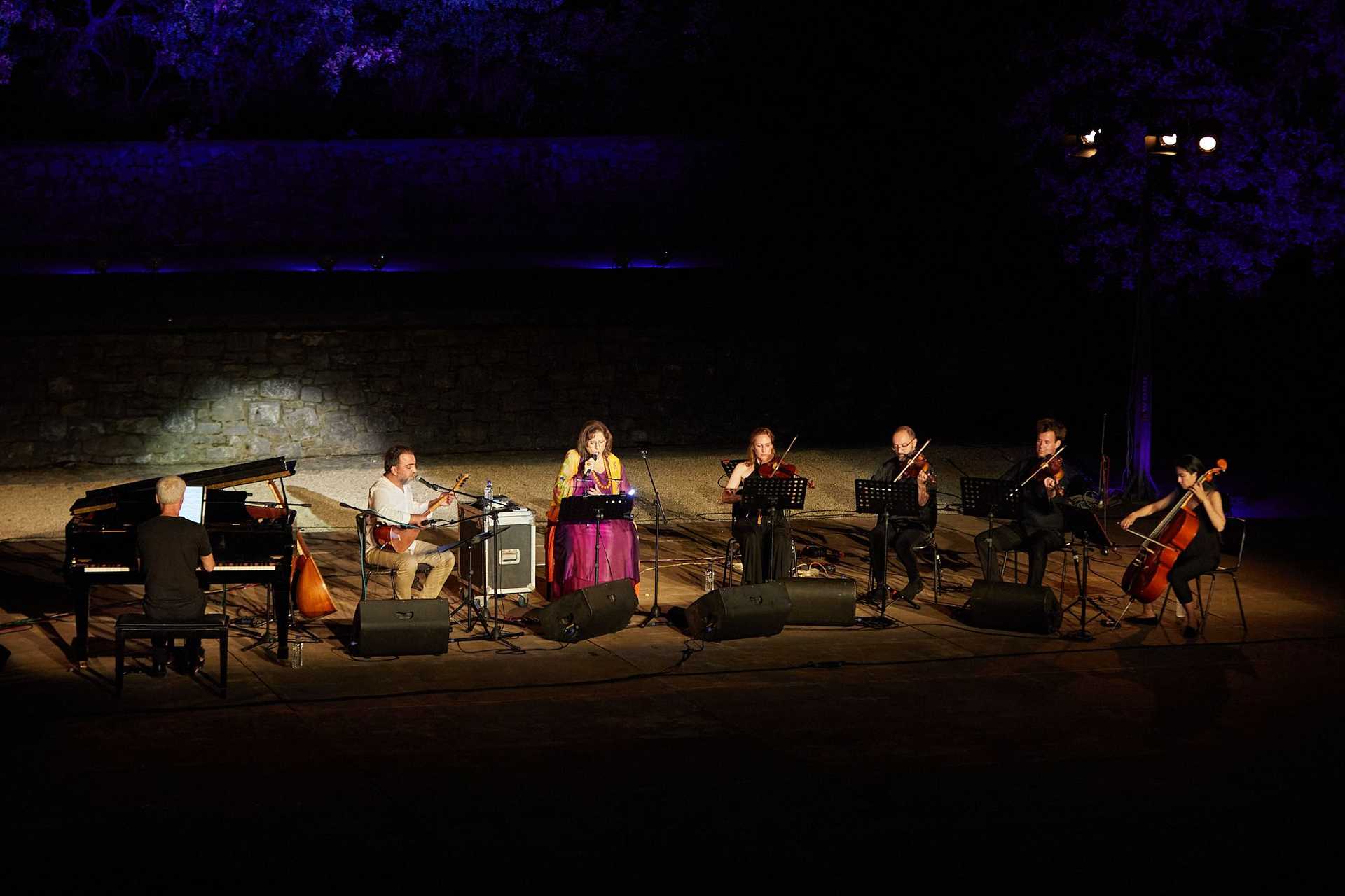 An orchester plays in the night on a rocky landscape