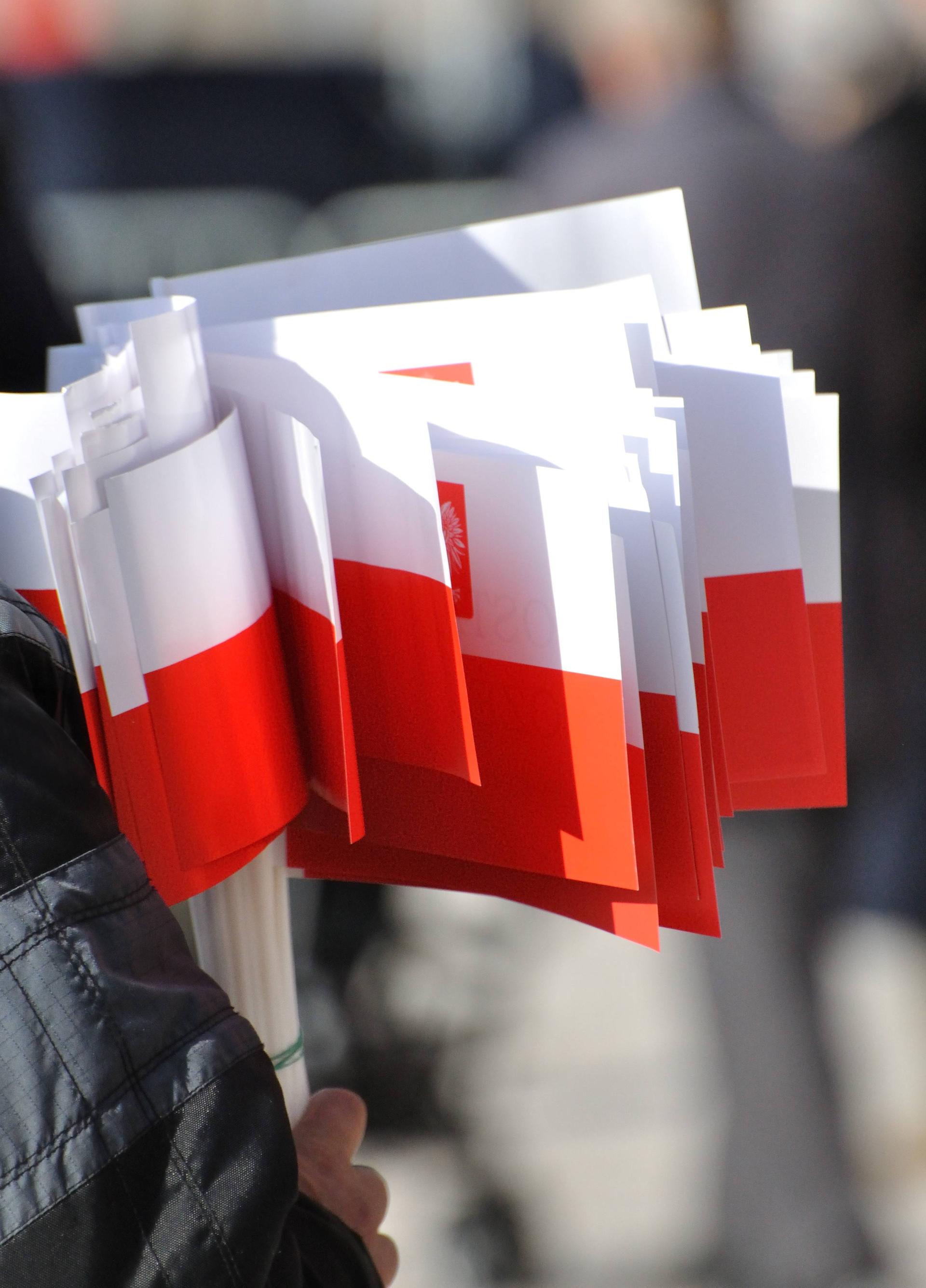 Many little polish swivel flags in the hand of a person