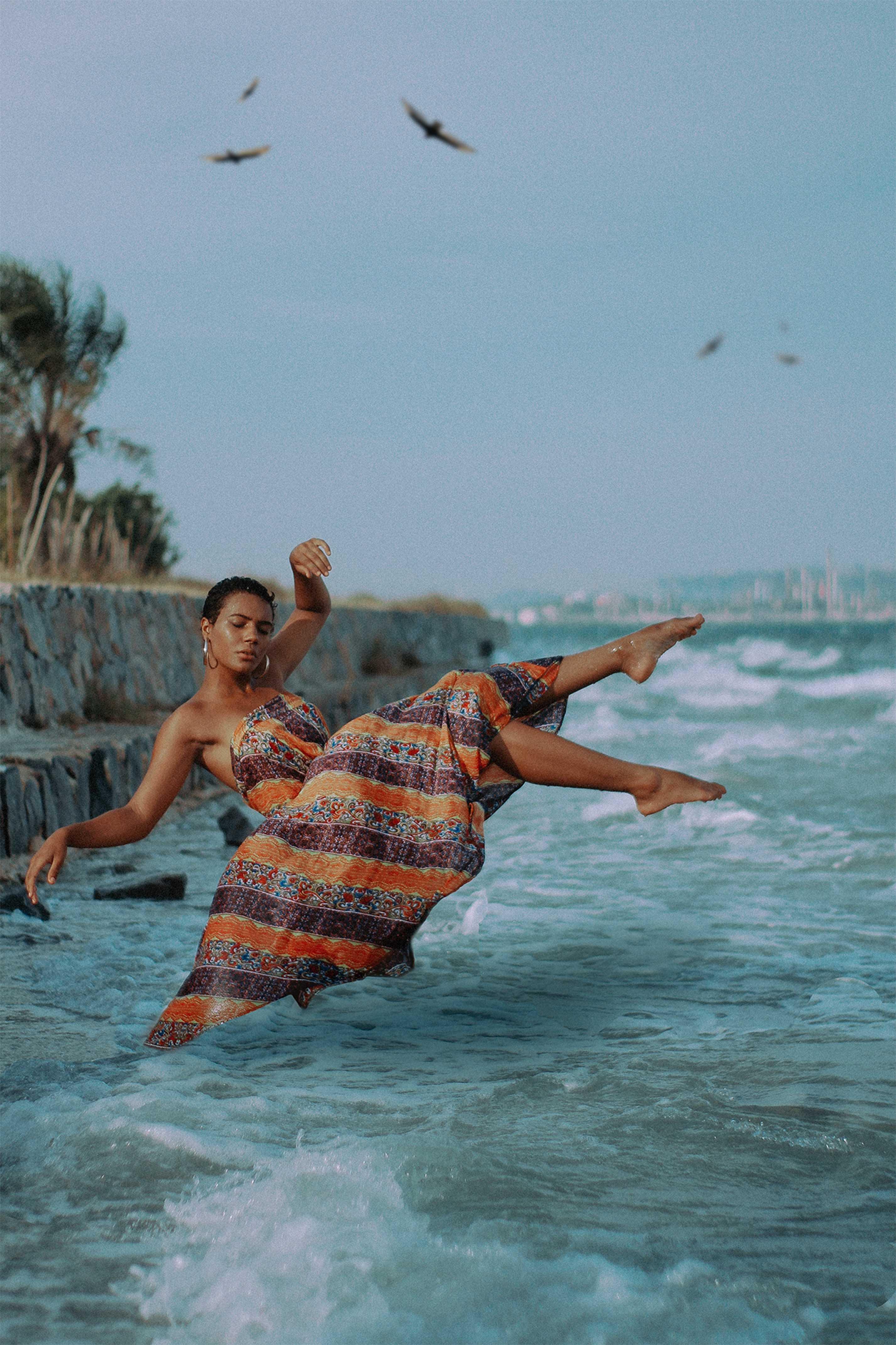 A woman hovers over waves and water