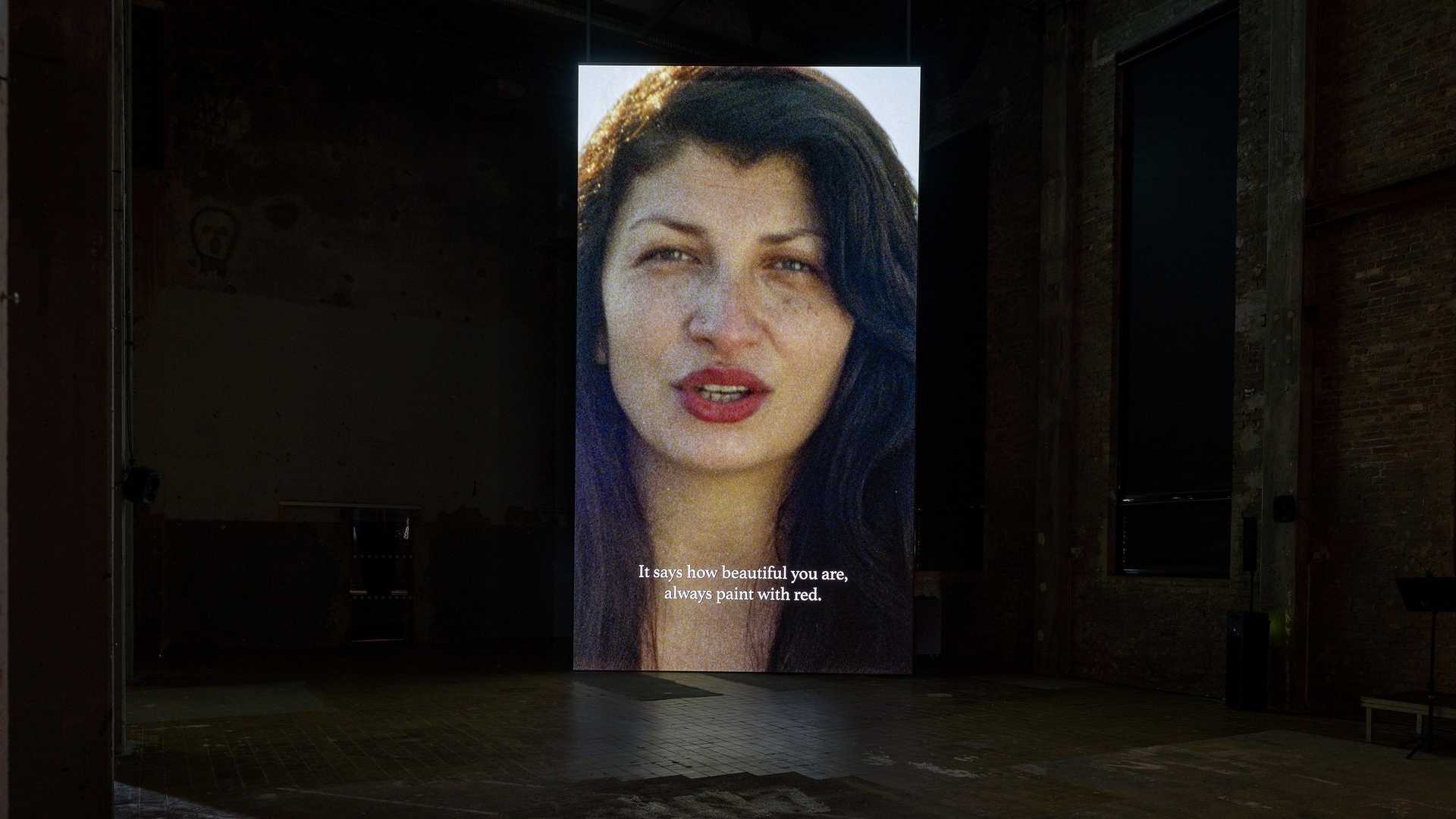 A vide installation with Selma Selman speaking to the audience