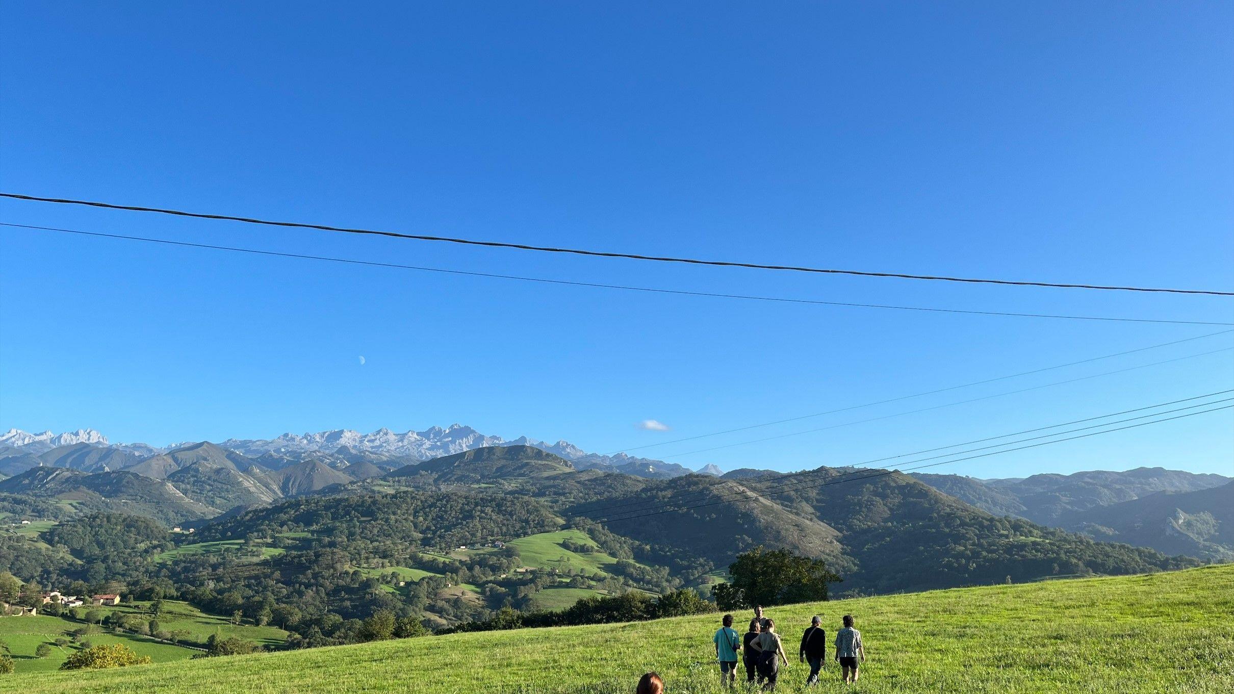 People walking over green hills