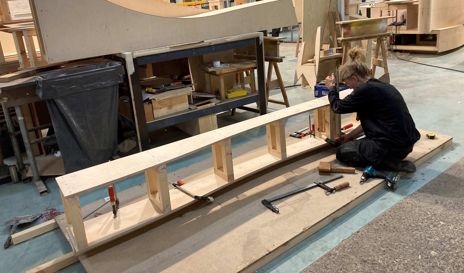 People are working on a wooden structure in of the Recyclarts workshop