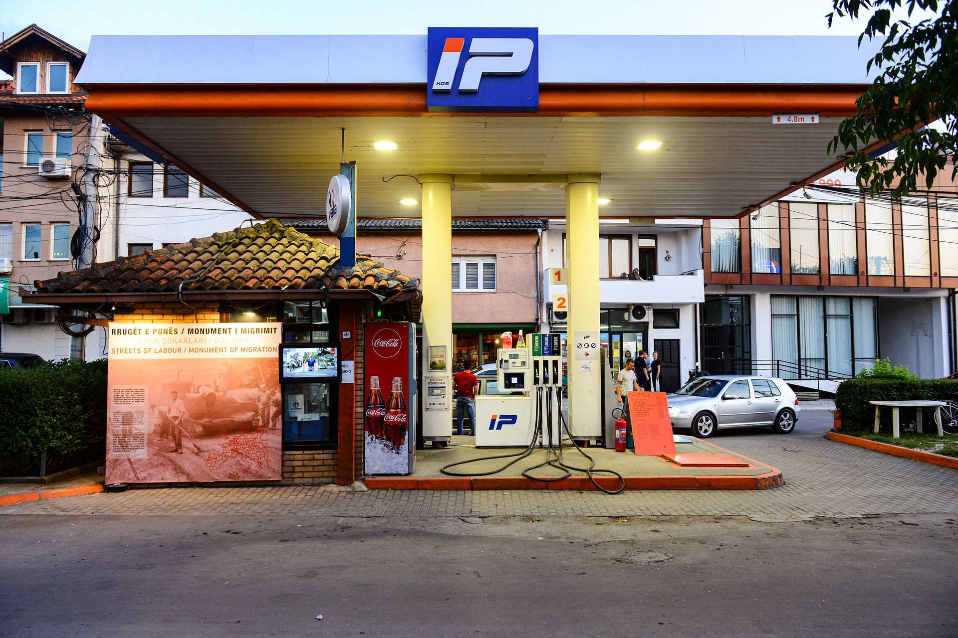 A wall of a petrol station is used as a display for historical documentation.