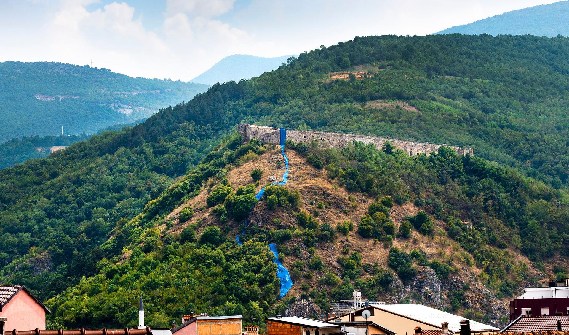 Streams of blue fabric by Hera Büyüktaşciya runs down a hill near Prizren