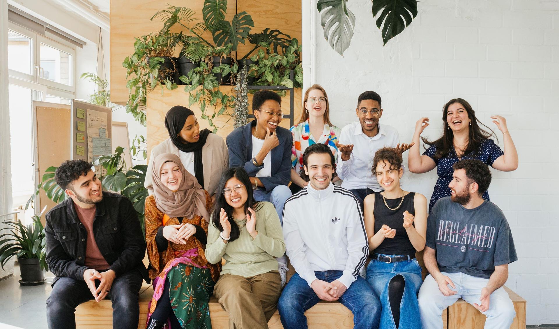 A group of people is sitting on a wooden structure.