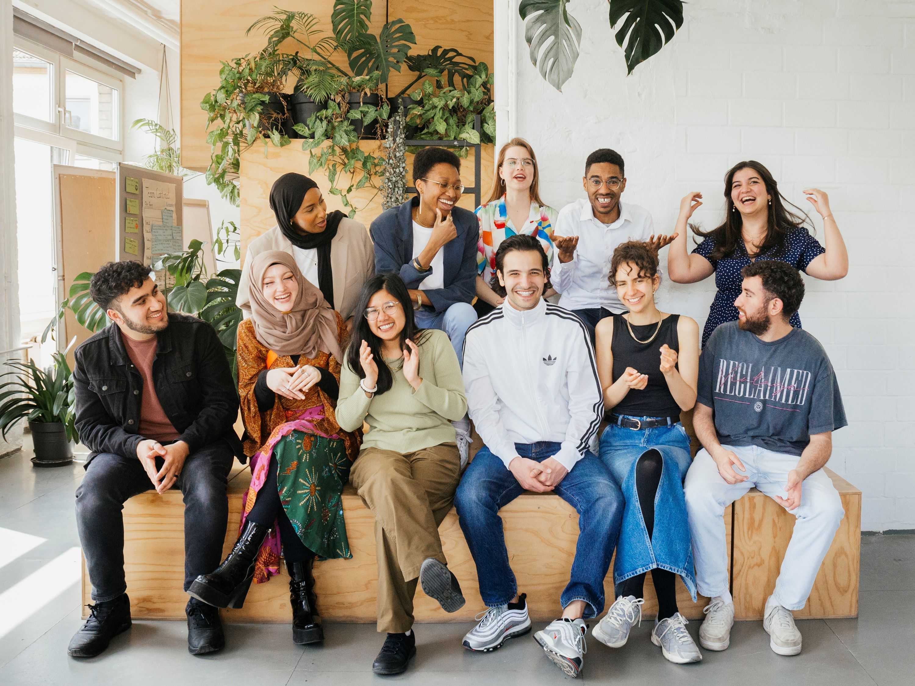 A group of people is sitting on a wooden structure.