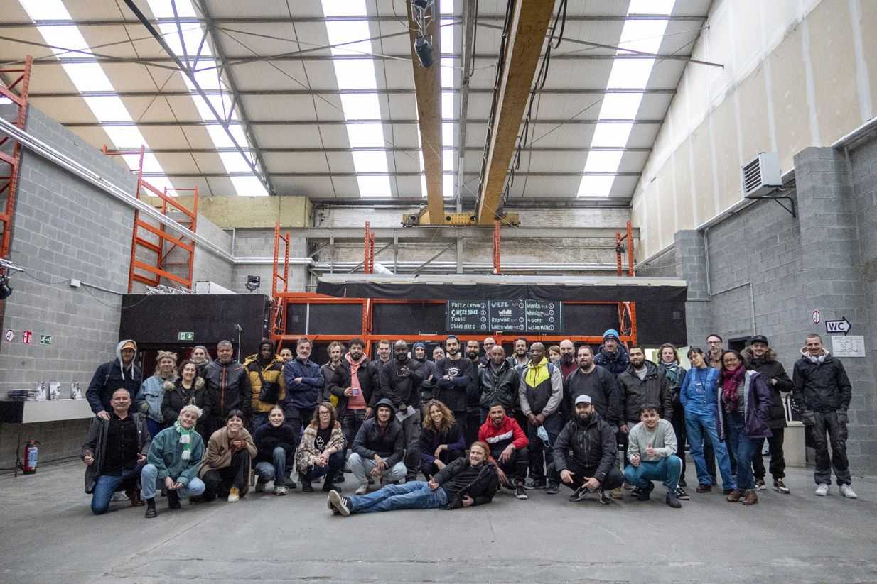 The team of Recyclart is standing in a workshop.