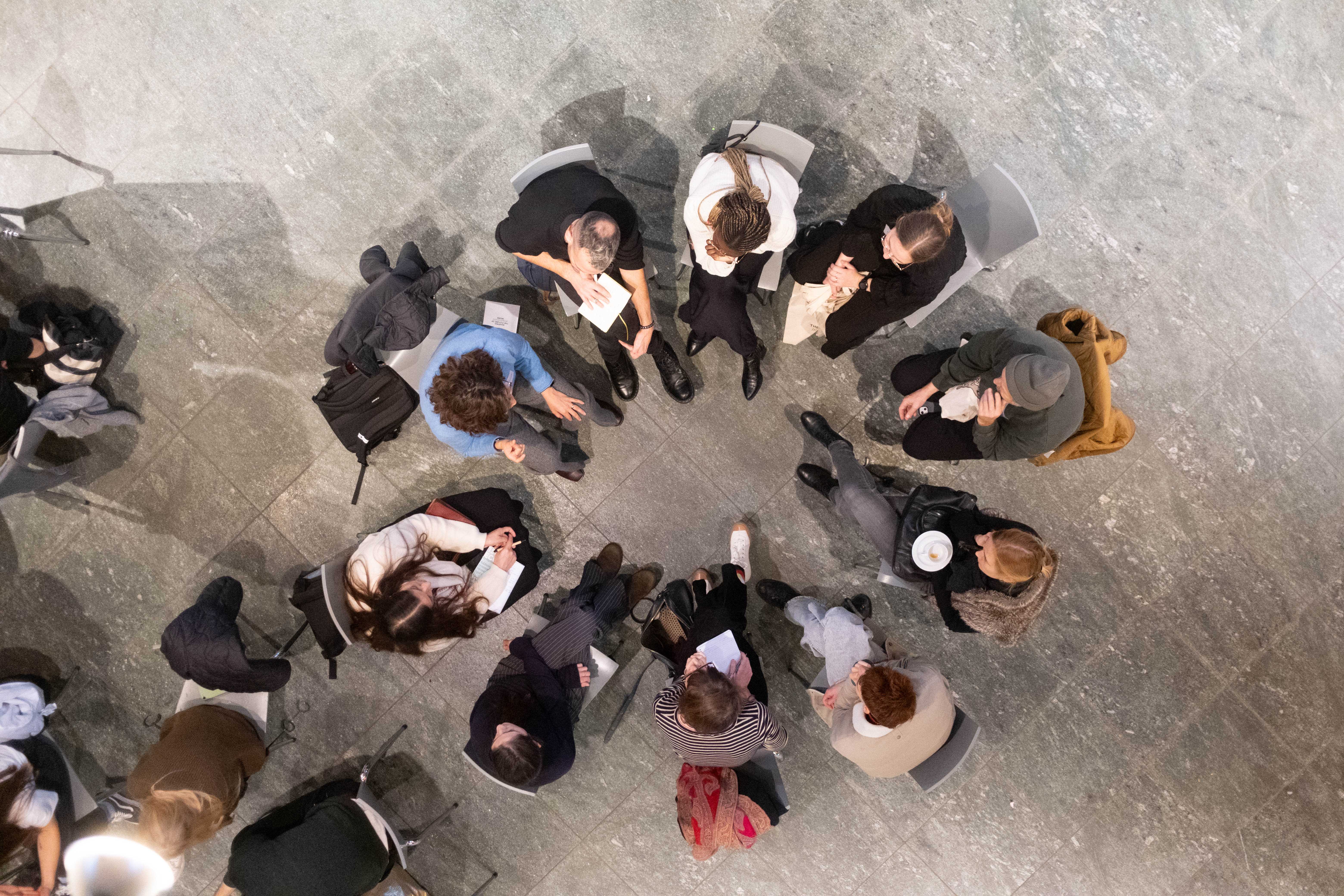 A group of people is sitting together in a circle and is talking