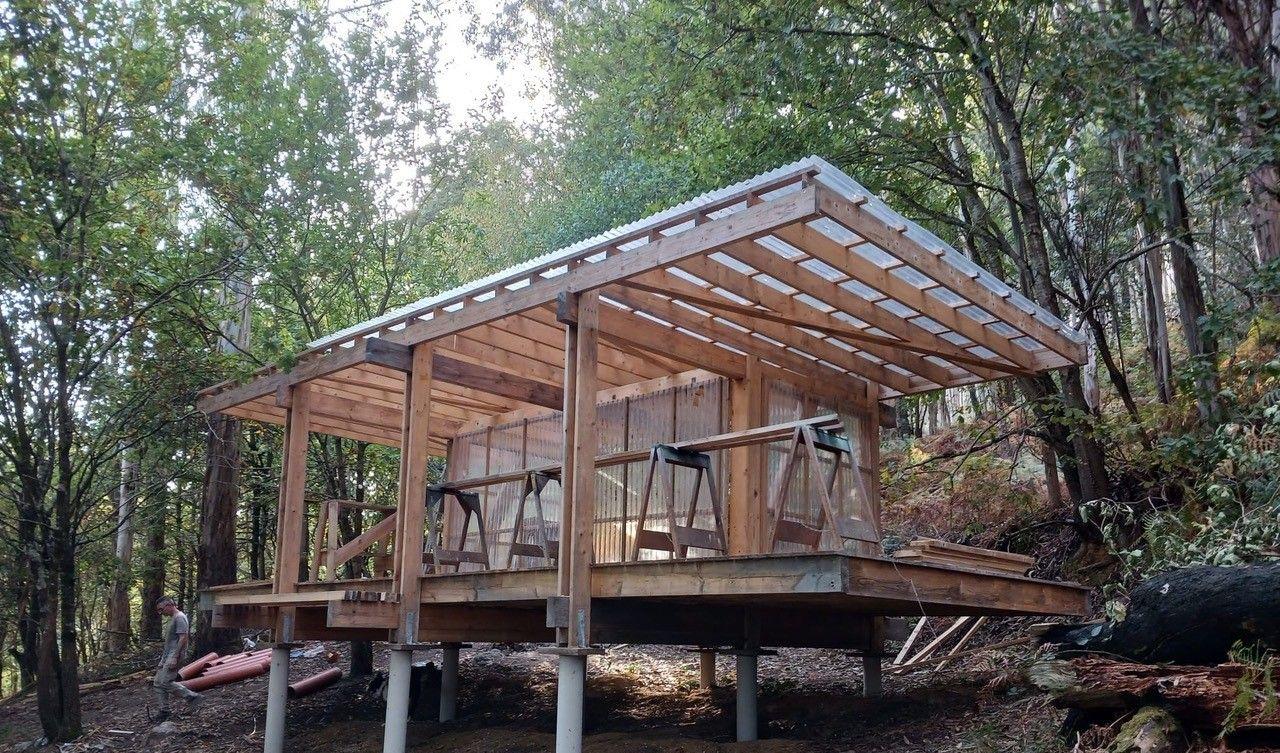 A wooden hut in the woods is under construction