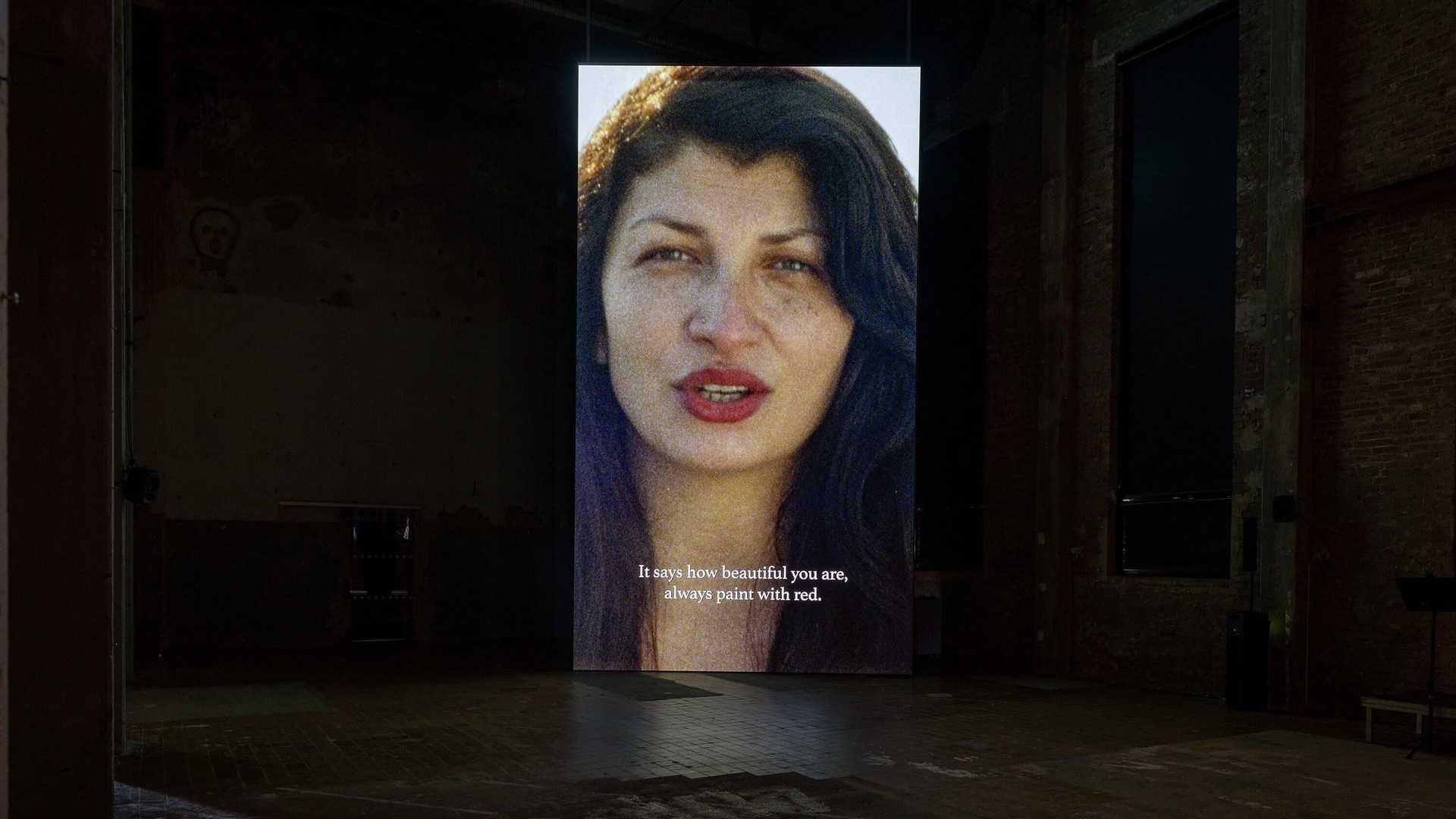 A vide installation with Selma Selman speaking to the audience